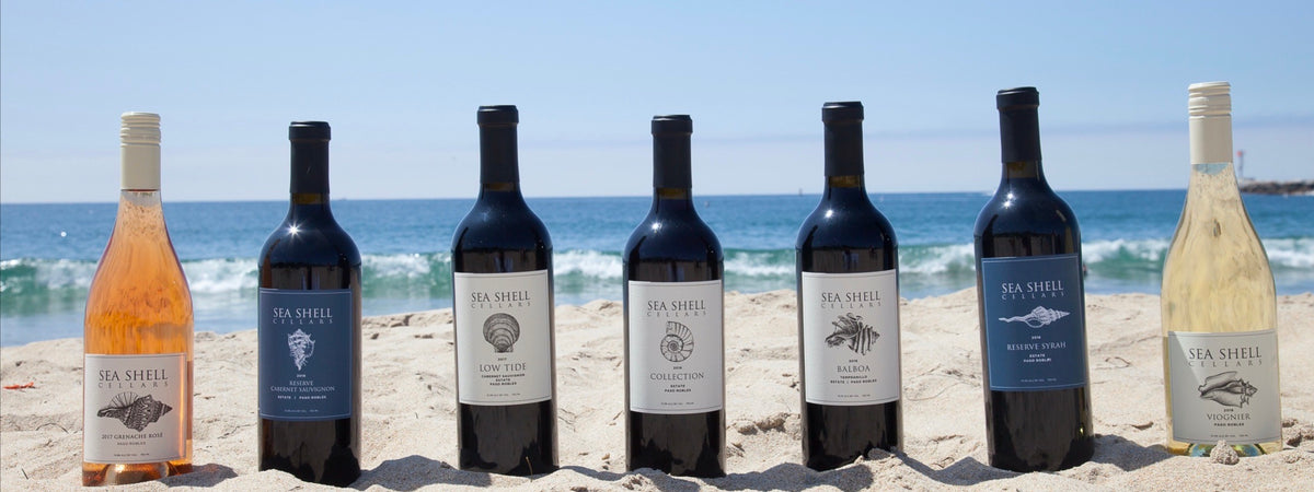 7 bottles of Sea Shell Cellars Wine sitting in the Sand on the beach in Paso Robles, CA